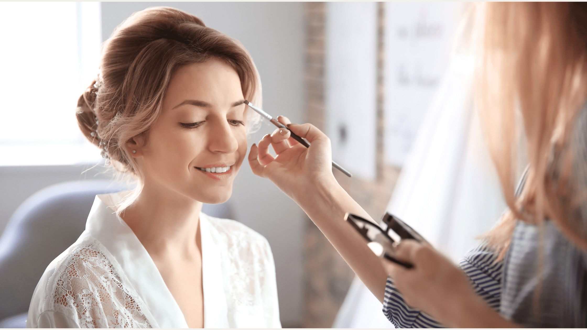 Makeup artist applying bridal makeup to a bride